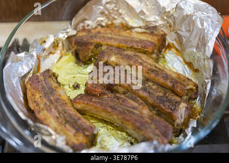 Costolette di maiale al forno con spezie in un piatto di casseruola di vetro Foto Stock