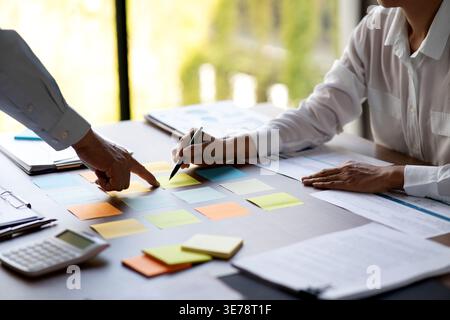 durante la riunione di brainstorming, il team di marketing sta selezionando le idee, note adesive adatte allo scopo di generare vendite e vantaggi nella pianificazione Foto Stock