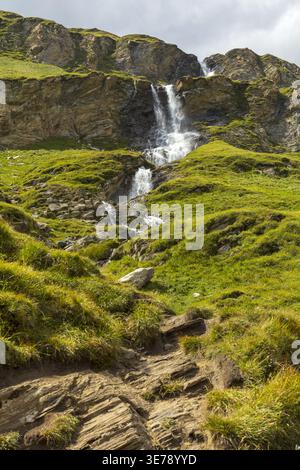 Piccola cascata che scorre attraverso il paesaggio alpino roccioso in Austria. Foto Stock