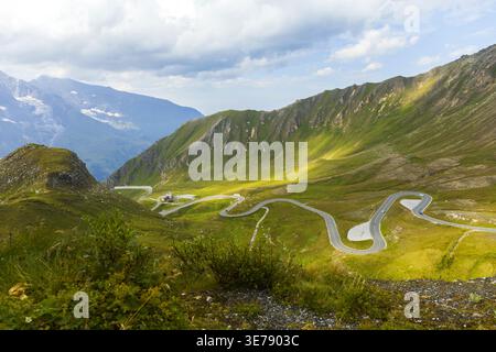 Strada panoramica tortuosa nelle Alpi austriache sulla strada alpina Grossglockner con luce solare sulle colline. Foto Stock