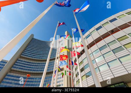 Vienna, Austria - 26 febbraio 2026: Il complesso del Vienna International Centre presenta moderne torri per uffici curve e bandiere internazionali sotto un trasparente BL Foto Stock