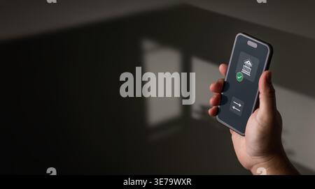 Primo piano di una persona con uno smartphone che visualizza un'app di mobile banking con icone di trasferimento e conferma in un'impostazione minima scura con copia spa Foto Stock