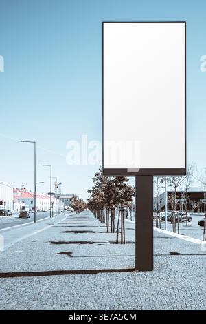 Grande tabellone bianco o mockup con schermo LED/LCD sul marciapiede urbano soleggiato, modello pubblicitario verticale per esterni con spazio fotocopie, perspecti stradali moderni Foto Stock