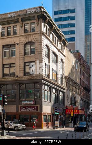 Boston, Massachusetts, Stati Uniti - i pedoni passano accanto alle aziende locali e ai colorati cartelli dei ristoranti di Chinatown. Foto Stock
