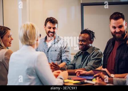 Lavoratore d'ufficio di sesso maschile di colore che incontra colleghi caucasici in ufficio Foto Stock