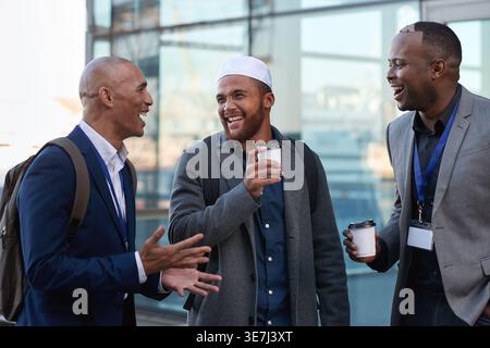 Persone che si trovano in città per ridere, per fare un caffè o per fare affari, per divertirsi e raccontare storie per sorridere. All'aperto, parlando e con un gruppo di uomini Foto Stock