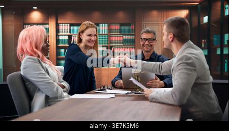 L'avvocato aziendale e il team stringono la mano dopo il successo della riunione di negoziazione legale. Foto Stock