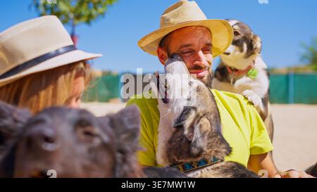 Coppia che interagisce allegramente con i cani al rifugio per animali Foto Stock