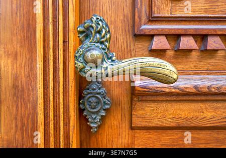 Maniglia in bronzo antico sulla porta in legno Foto Stock