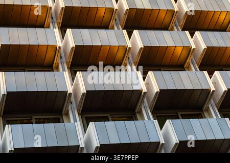 Primo piano. Sfondo. Architettura urbana. Facciata di un edificio moderno con balconi alla luce del sole che tramonta. Atene, Grecia Foto Stock