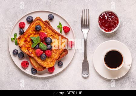 Toast alla francese con mirtilli, lamponi, sciroppo d'acero, vista dall'alto. Foto Stock