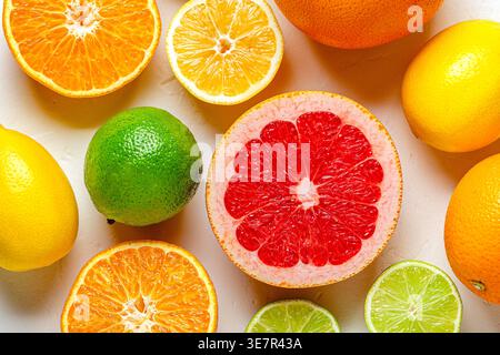 Limone fresco, arancia, pompelmo, lime su sfondo chiaro, vista dall'alto. Succo di agrumi, vitamina C, frutta. Foto Stock