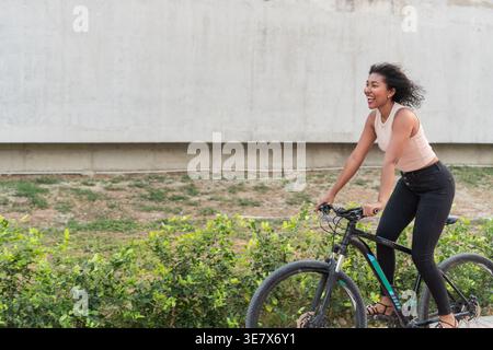 La donna nera ama andare in bicicletta all'aperto durante il giorno Foto Stock