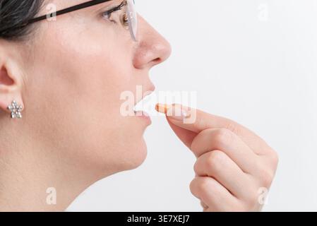 Donna che prende pillole da vicino, assunzione di farmaci e concetto di trattamento sanitario Foto Stock