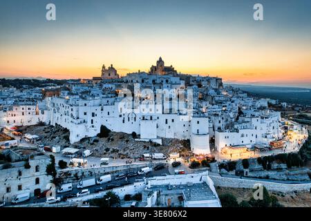 Vista aerea di Ostuni, la città Bianca in Puglia, Italia, al tramonto. Storico skyline della città vecchia con edifici illuminati al crepuscolo Foto Stock