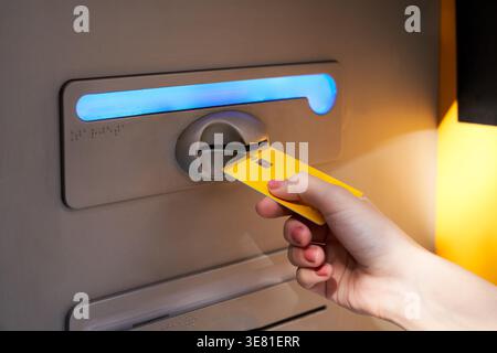 Donna giapponese in piedi per strada e ritirare soldi dal bancomat durante il giorno Foto Stock