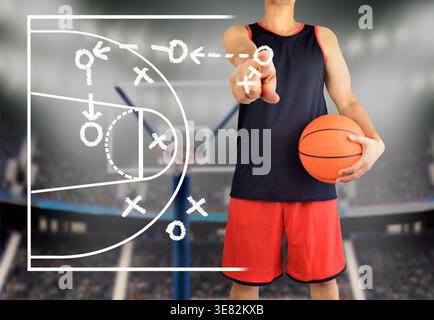 mano di un allenatore di pallacanestro che disegna una tattica di basket con gesso bianco sulla lavagna dello stadio dell'arena Foto Stock