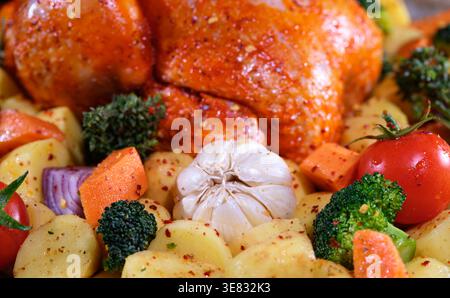 Abbondante festa di famiglia con pollo arrosto e verdure colorate Foto Stock
