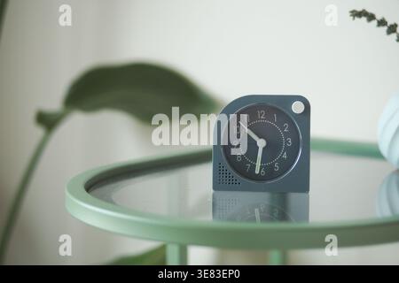 Orologio semplice su un tavolo verde in una stanza luminosa Foto Stock
