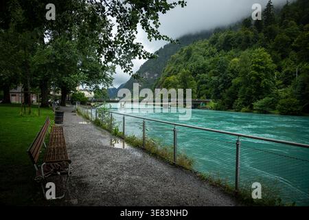 Passeggiata lungo il fiume lungo le acque turchesi del fiume Aare a Interlaken, Svizzera Foto Stock