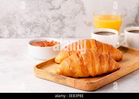 Caffè caldo, croissant su sfondo chiaro, messa a fuoco selettiva. Colazione Foto Stock
