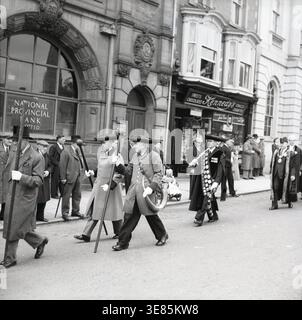 Soffiatori di corno in processione, Ripon, Yorkshire, c1955. Ogni notte viene soffiato un corno ai quattro angoli dell'Obelisco nella piazza del mercato di Ripon per mettere l'orologio, e poi fuori dalla casa del sindaco. Questa cerimonia commemora il tempo nel Medioevo in cui il primo cittadino di Ripon, il Wakeman, era responsabile della prevenzione del crimine in città dalle 21:00 all'alba e doveva risarcire le vittime di furto. Foto Stock