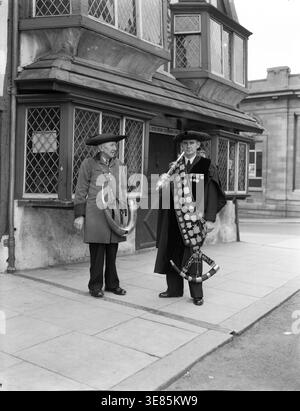 Soffiatori di trombe, Ripon, Yorkshire, c1955. Ogni notte viene soffiato un corno ai quattro angoli dell'Obelisco nella piazza del mercato di Ripon per mettere l'orologio, e poi fuori dalla casa del sindaco. Questa cerimonia commemora il tempo nel Medioevo in cui il primo cittadino di Ripon, il Wakeman, era responsabile della prevenzione del crimine in città dalle 21:00 all'alba e doveva risarcire le vittime di furto. Foto Stock