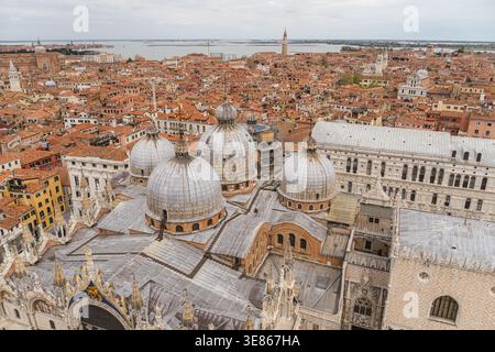 Vista panoramica sopraelevata su Venezia, Italia, con cupole storiche della basilica, architettura in pietra ornata e tetti in terracotta che si estendono verso la l Foto Stock