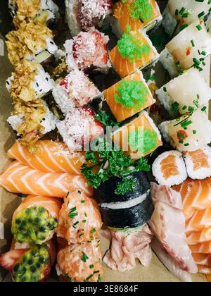 Primo piano di piatti di sushi assortiti con nigiri di salmone, maki roll e morsi con ripieno di riso, rifiniti con erbe e guarnire per un fresco giapponese Foto Stock