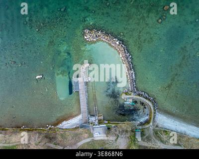 Una splendida vista aerea del lago di Ginevra catturata da un drone, che rivela le limpide acque turchesi, la costa rocciosa e un tranquillo paesaggio panoramico Foto Stock