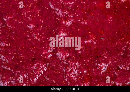 Fragole fresche tritate rustiche schiacciate in marmellata, consistenza spessa e lucida, semi visibili e tasche sciroppate, segni a cucchiaio, conserva l'umore artigianale Foto Stock