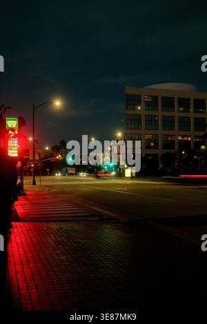 Strada urbana di notte con riflessi al neon sul marciapiede a Los Angeles, California, Stati Uniti Foto Stock