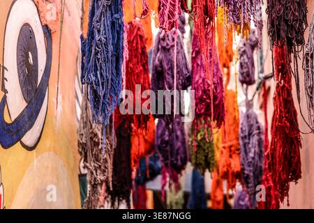Mazzi colorati di filato di lana tinti appesi ad asciugare in un vicolo stretto della medina di Marrakech, Marocco Foto Stock