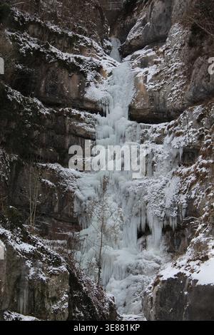 Una spettacolare cascata ghiacciata con enormi ghiaccioli aggrappati a una ripida parete rocciosa nella Valle Echerntal vicino a Hallstatt, Austria, durante l'inverno. Foto Stock