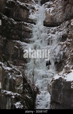 Una spettacolare cascata ghiacciata con enormi ghiaccioli aggrappati a una ripida parete rocciosa nella Valle Echerntal vicino a Hallstatt, Austria, durante l'inverno. Foto Stock