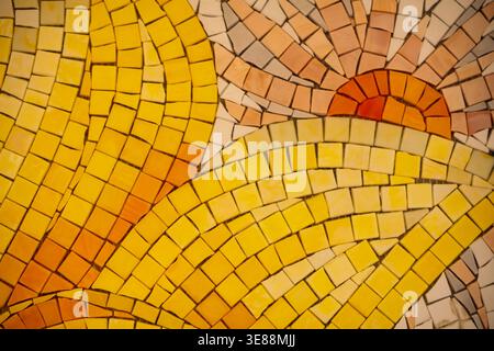 Piastrelle a mosaico gialle e arancioni che formano un sole, onde e cielo stilizzati Foto Stock