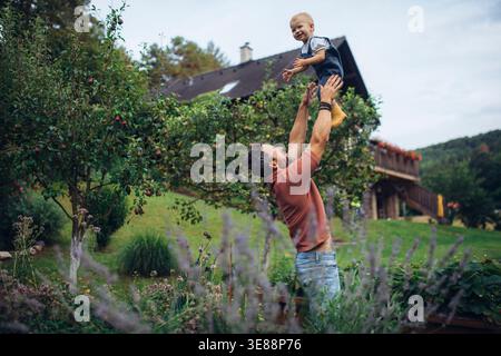 Padre che gioca con la figlia mentre passa del tempo insieme in giardino. Foto Stock