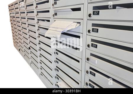 Cassette postali bianche in metallo con alloggiamenti numerati e buste. File di caselle postali per edifici residenziali o complessi di appartamenti. Comunicazione, de Foto Stock