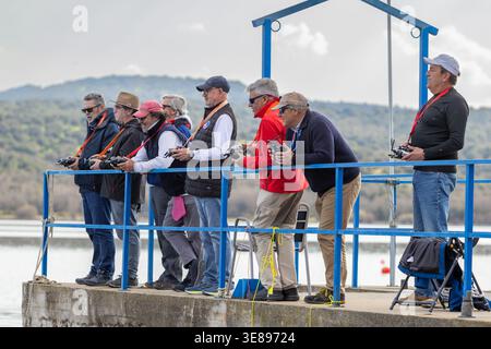 Gruppi di anziani che osservano barche modello che si muovono sull'acqua. Foto Stock