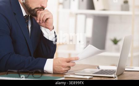 Responsabile finanziario che lavora con documenti e laptop Foto Stock
