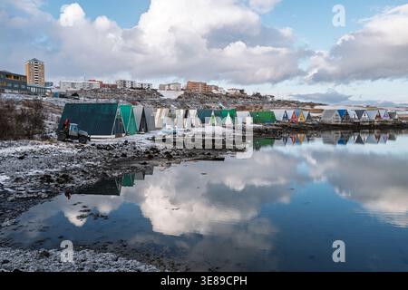 Case colorate per barche a Hvaleyralón a Hafnarfjörður, una tranquilla scena invernale sul lungomare nel sud-ovest dell'Islanda Foto Stock