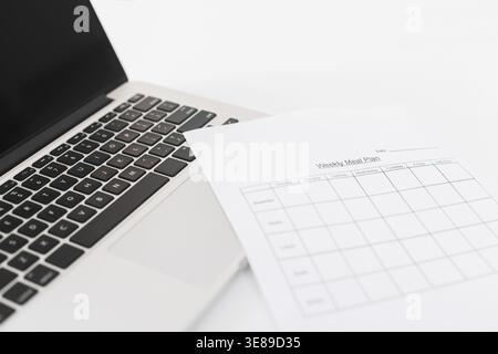 Pasti per la settimana su carta e laptop Foto Stock