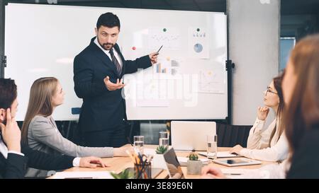 Manager finanziario dando la presentazione ai colleghi in ufficio Foto Stock
