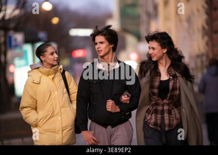 Gruppo di giovani amici che camminano lungo la strada della città. Foto Stock