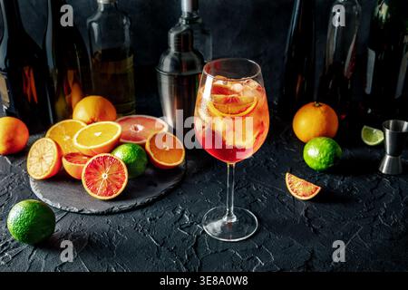 Aperol Spritz, cocktail con arance e spumante, in un bar, con agrumi e bottiglie di alcol Foto Stock