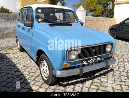 Renault 4 vintage azzurra parcheggiata in una tradizionale strada acciottolata in Portogallo con tetto bianco e classico paraurti cromato Foto Stock