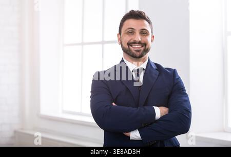 Uomo d'affari di successo che guarda la fotocamera e sorride Foto Stock