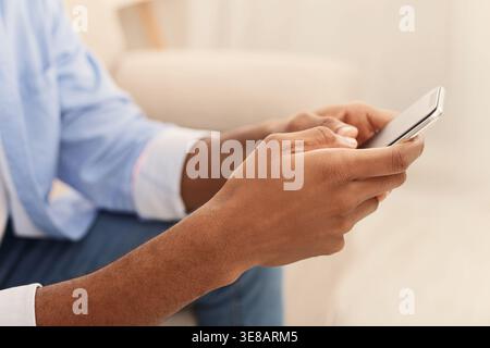 Giovane uomo utilizzando i moderni smartphone a home Foto Stock