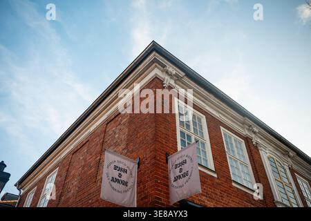 Bussi & amore Bistro nello storico quartiere olandese. Immagine ad angolo basso della facciata in mattoni rossi del bistro Bussi & amore con bandiere bianche. Foto Stock