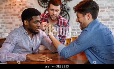 I vecchi amici avente il braccio di wrestling, sfida in un pub. Foto Stock